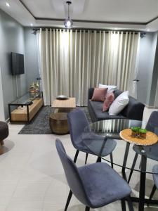 sala de estar con sofá, mesa y sillas en Posh 3 bedroomed guesthouse in Hillside with pool - 2039, en Bulawayo