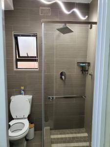 uma casa de banho com um WC e uma cabina de duche em vidro. em Posh 3 bedroomed guesthouse in Hillside with pool - 2039 em Bulawayo