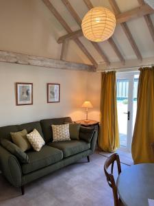 a living room with a couch and a table at The Calf Shed - cozy cottage in peaceful Norfolk countryside in Aldeby