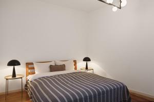 een witte slaapkamer met een bed en 2 lampen bij Vidikovac Marble House in Budva