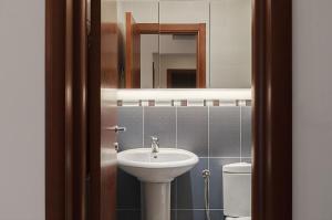 een badkamer met een wastafel, een spiegel en een toilet bij Vidikovac Marble House in Budva