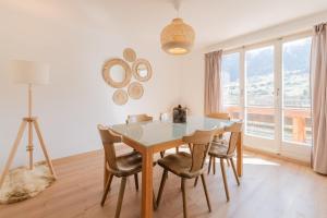 a dining room with a table and chairs and a window at The Eiger Express Apartment - GRINDELHOMES in Grindelwald