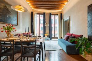 a living room with a table and a blue couch at Cà dei Dalmati - the Blue Canal View in Venice