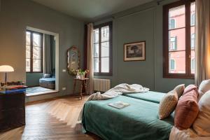 1 dormitorio con 1 cama en una habitación con ventanas en Cà dei Dalmati - the Blue Canal View en Venecia