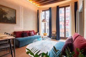 a living room with a couch and a table at Cà dei Dalmati - the Blue Canal View in Venice