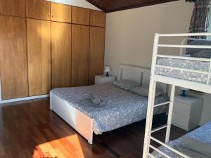 ein Schlafzimmer mit einem Etagenbett und einer Leiter in der Unterkunft Citrus Tree House, private pool and garden. in Angeja