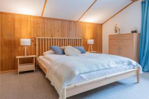 ein Schlafzimmer mit einem großen Bett und einer Holzwand in der Unterkunft The Eiger Express Apartment - GRINDELHOMES in Grindelwald