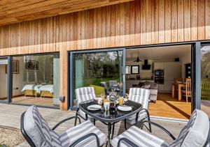 a patio with a table and chairs on a deck at River Birch in Beckley