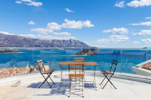 a table and chairs on a balcony with a view of the water at Vidikovac Marble House in Budva