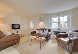 a living room with leather furniture and a tv at Napier Cottage in Broadstairs