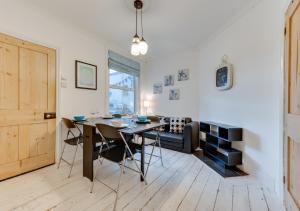 a dining room with a table and chairs and a couch at Millers Cottage in Broadstairs