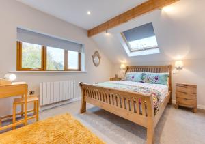 a bedroom with a bed and a desk and a skylight at Swallows Return in Bilsington