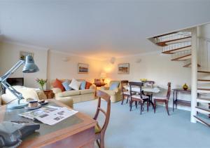 ein Wohnzimmer mit einem Sofa und einem Tisch in der Unterkunft Stable Mews Cottage in Royal Tunbridge Wells