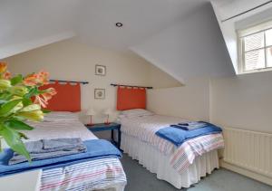 a bedroom with two beds and a window at Stable Mews Cottage in Royal Tunbridge Wells