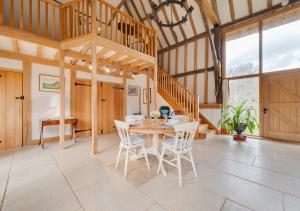 a dining room with a wooden table and chairs at Strawberry Hole Barn in Northiam