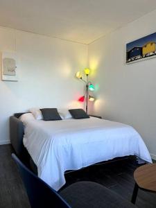 スラック・シュル・メールにあるAppartement vue merのベッドルーム(白いベッド1台、テーブル付)