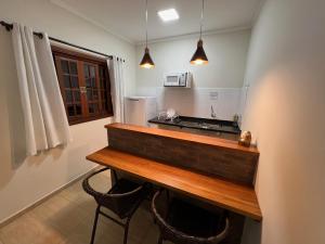 a kitchen with a counter with two chairs and a counter top at Pousada Terra Rossa in São José do Rio Pardo