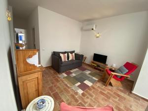 een woonkamer met een bank en een televisie bij Casa Bidu by Homekeys in Santa Luzia