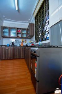 a kitchen with stainless steel appliances and wooden cabinets at Elegant 2bedroom apartments close to city center in Kampala