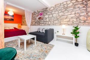 a bedroom with a bed and a stone wall at Studio Apartment Bisaku in Rovinj