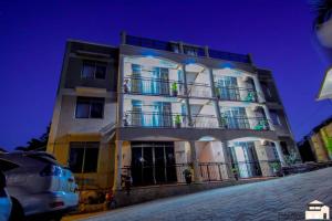 a tall white building with a balcony on a street at Elegant 2bedroom apartments close to city center in Kampala