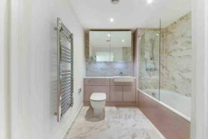 a bathroom with a toilet and a tub and a sink at Modern & Spacious Luxury Flat-10 min to London Eye in London