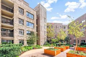 an apartment building with plants in front of it at Modern & Spacious Luxury Flat-10 min to London Eye in London