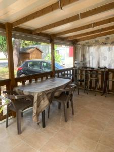 a wooden table and chairs on a porch with a car at Mobil home La Coulumiere in La Tremblade