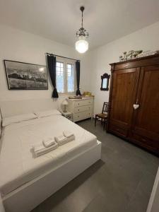 1 dormitorio con 1 cama blanca grande y vestidor en Residenza SA - tra mare e campagna, en Sannicola