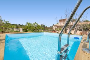 ein blauer Pool mit Stühlen neben einem Haus in der Unterkunft Sa Caseta -Búger- in Búger