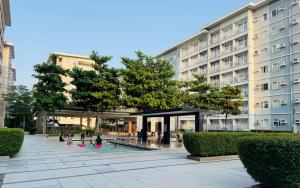 a building with a swimming pool in front of a building at Trees Residences - Tower 11 1BR with Balcony in Manila