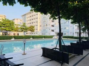 a swimming pool with benches and a building at Trees Residences - Tower 11 1BR with Balcony in Manila
