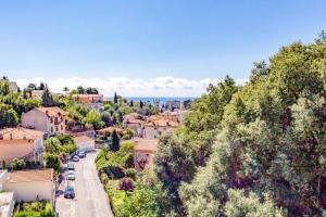a view of a town from a hill with trees at L36 Sea view terrace 10min walking to sea/Parking & AC in Nice