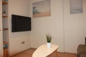 a living room with a table and a tv on a wall at L36 Sea view terrace 10min walking to sea/Parking & AC in Nice
