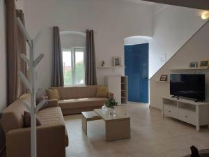 een woonkamer met een bank en een tv bij Lion's House in Kalymnos