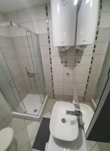 łazienka z toaletą, umywalką i prysznicem w obiekcie Cacak Central w mieście Čačak