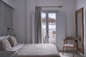 Schlafzimmer mit einem Bett und Meerblick in der Unterkunft Makris Beach Hotel in Kamari