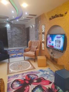 un soggiorno con sedia e TV di MILAشقق مهندسين a Il Cairo