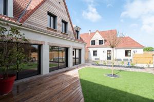 a house with a courtyard with a tree in the yard at L'ORIGINE in Saint-Aubin