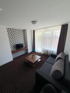 a living room with a couch and a coffee table at Plage Carpe Diem 2 Apartman in Hajdúszoboszló