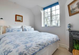1 dormitorio con 1 cama con edredón azul y blanco en The Coach House en Biddenden