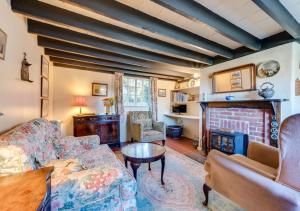 a living room with a couch and a fireplace at Thatch Cottage in Shoreham-by-Sea