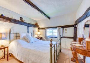 a bedroom with a white bed and a window at Thatch Cottage in Shoreham-by-Sea