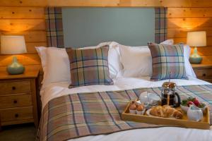 a bed with a tray of food on it at Stable Lodge in Drymen