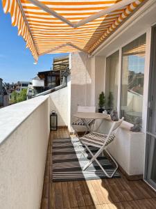 a balcony with a table and chairs and an umbrella at Dockview atelier in Burgas