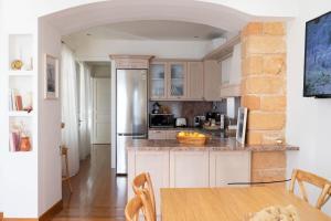a kitchen with white cabinets and a wooden table at Naias Aegina, Sea-front apartment 95 sqm in Aegina Town