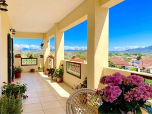 a balcony with flowers and a view of the mountains at VILLA GREEN VALLEY in Velonádes