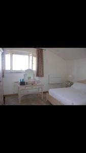 sypialnia z łóżkiem, biurkiem i oknem w obiekcie Affittasi a Capalbio per un minimo di 5 notti w mieście Capalbio