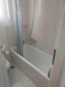 een witte badkamer met een bad en een toilet bij Affittasi a Capalbio per un minimo di 5 notti in Capalbio