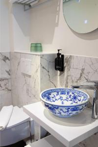 een wastafel in de badkamer met een blauwe en witte kom op een plank bij Hotel des Arts in Amsterdam